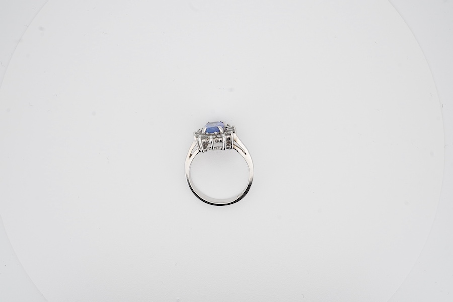 A modern 14k white metal, tanzanite and diamond set oval cluster ring, size M, gross weight 4.3 grams.